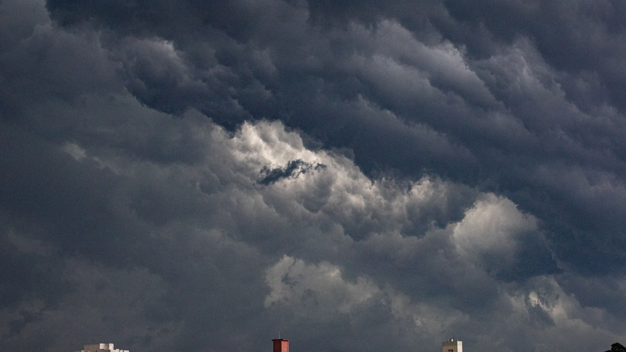 High-rise buildings under dark, dramatic cloud