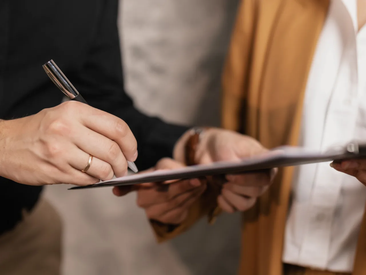 Two professionals signing a business document together
