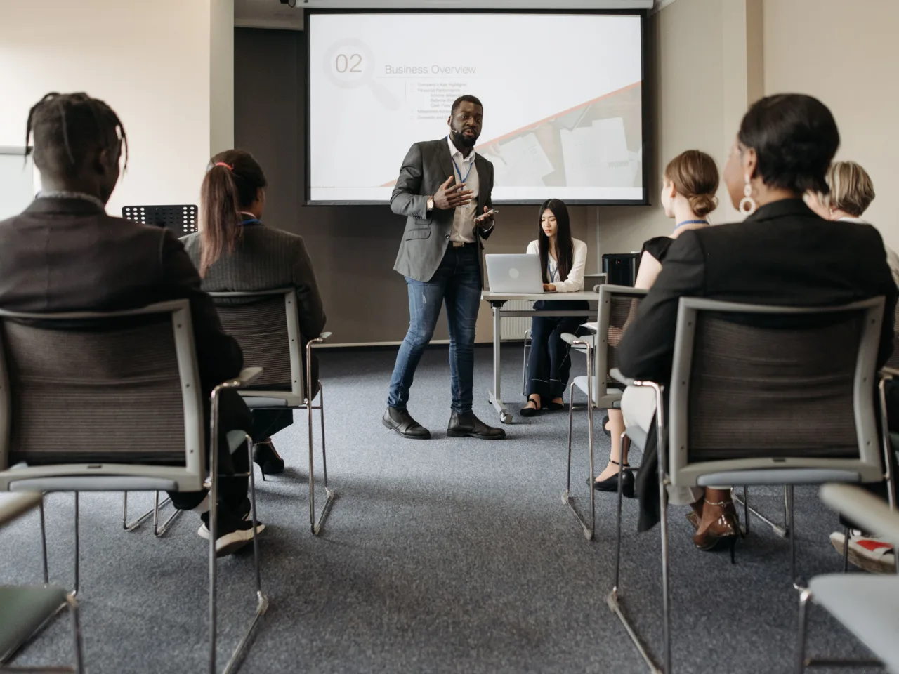 Business seminar, presenter and screen, seated audience